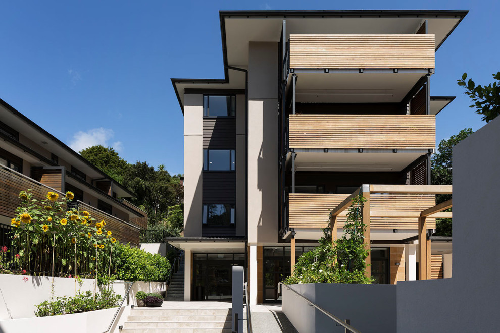 Ispirazione per la facciata di un appartamento grigio contemporaneo a quattro piani con rivestimento con lastre in cemento e tetto piano