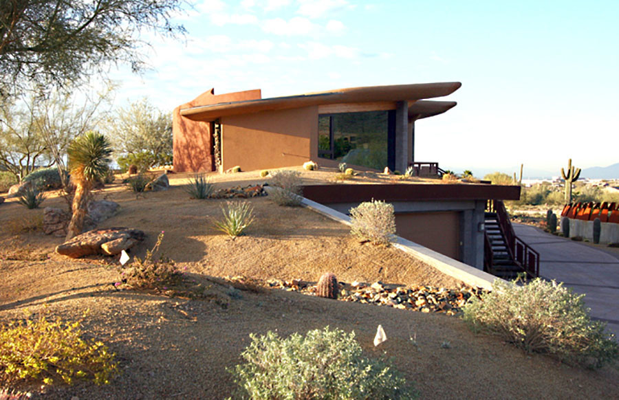 Small contemporary orange two-story stucco exterior home idea in Phoenix with a green roof