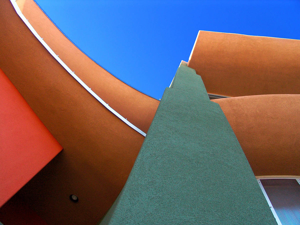 Idées déco pour une façade de maison orange moderne de taille moyenne et à un étage avec un toit en métal.