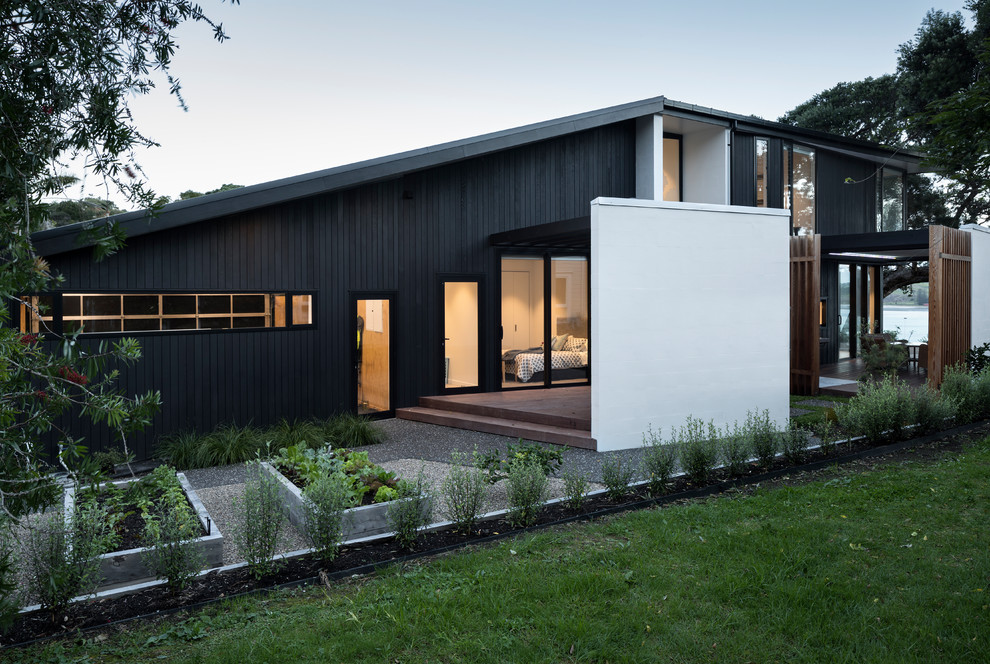 Mittelgroßes, Zweistöckiges Modernes Einfamilienhaus mit Mix-Fassade, schwarzer Fassadenfarbe und Blechdach in Sonstige