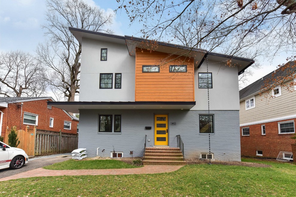 Ejemplo de fachada de casa multicolor moderna de tamaño medio de tres plantas con revestimientos combinados