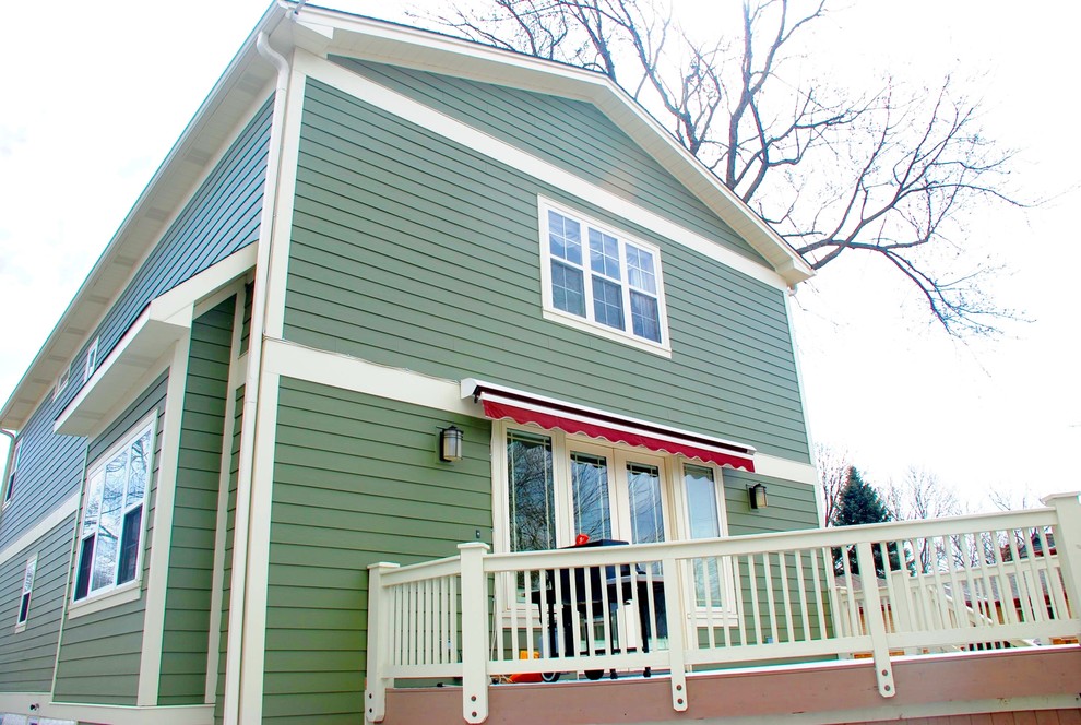 Mittelgroßes, Zweistöckiges Country Einfamilienhaus mit Faserzement-Fassade, grüner Fassadenfarbe, Satteldach und Schindeldach in Sonstige