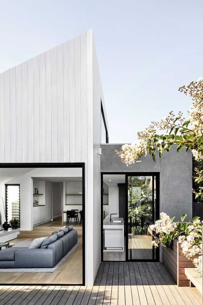 Exemple d'une façade de maison grise tendance en bois de taille moyenne et de plain-pied avec un toit à deux pans et un toit en métal.