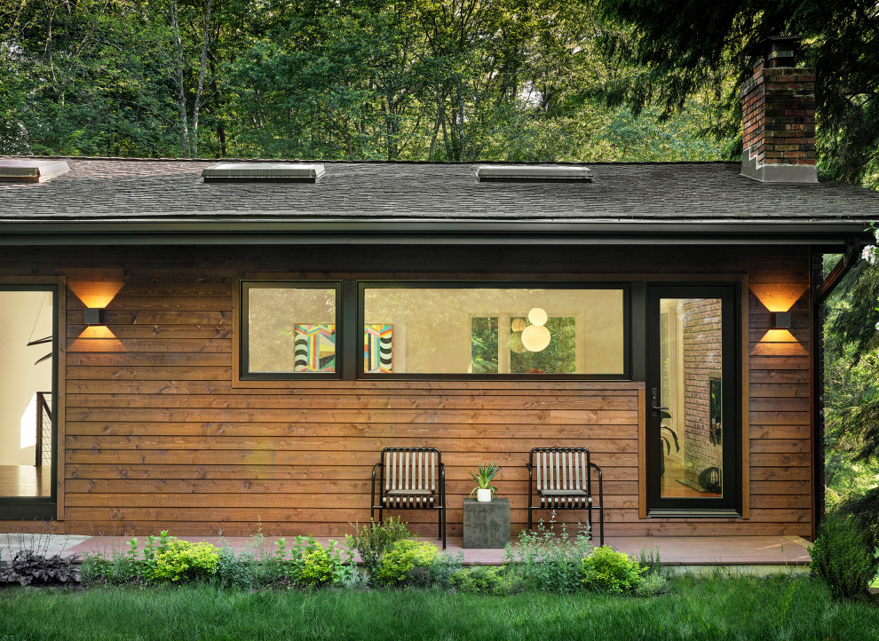Cette photo montre une façade de maison moderne en bois de taille moyenne et à un étage avec un toit à deux pans et un toit en shingle.