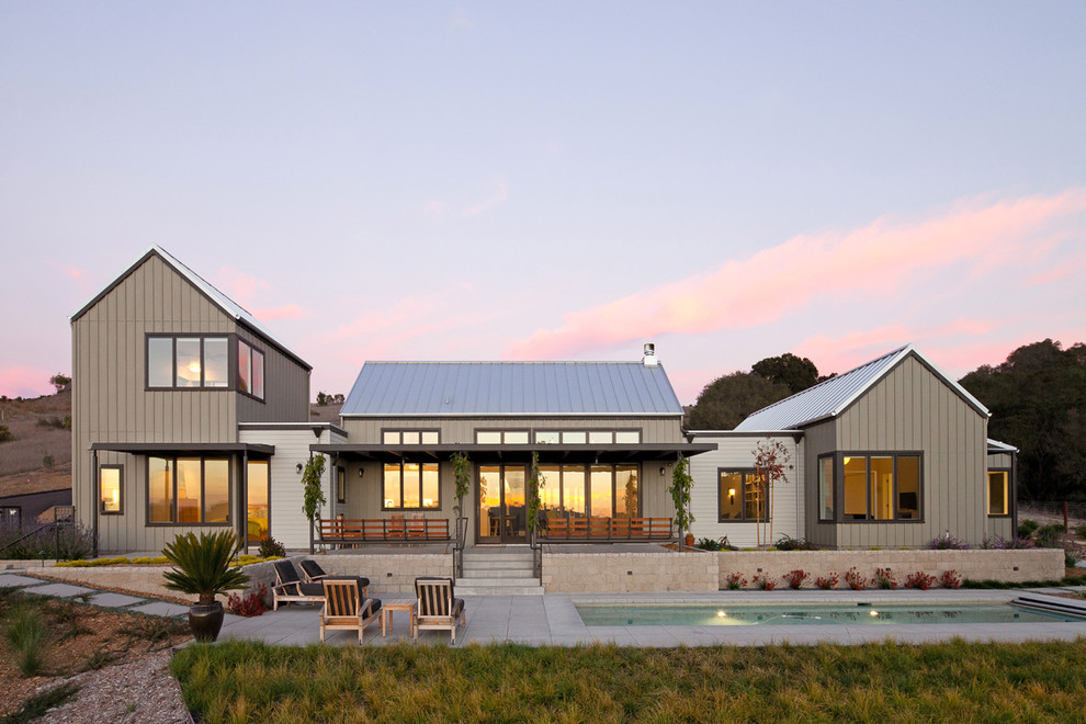 Идея дизайна: двухэтажный, серый дом в стиле кантри с двускатной крышей и металлической крышей
