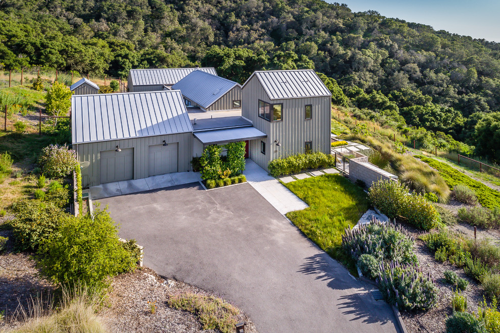 Foto de fachada gris de estilo de casa de campo de dos plantas con tejado a dos aguas y tejado de metal