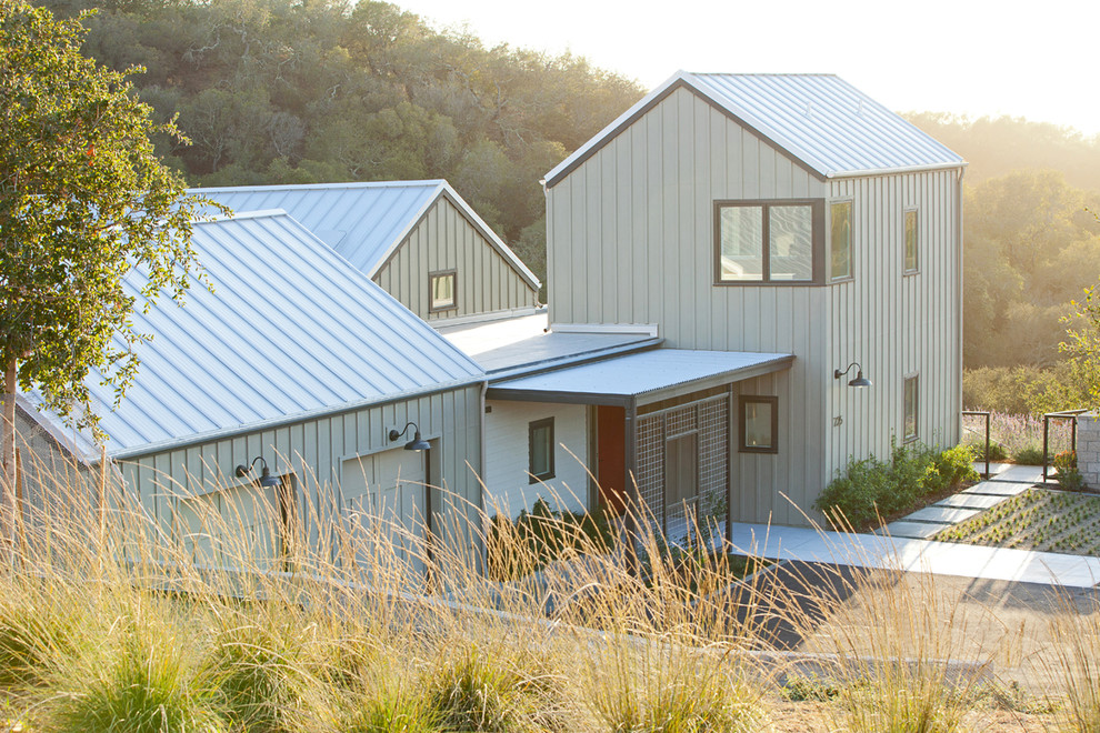 Idées déco pour une façade de maison grise campagne à un étage avec un toit à deux pans.