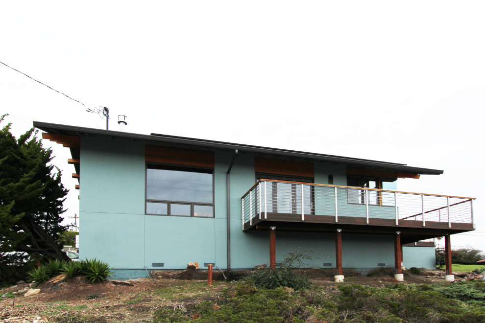 Ejemplo de fachada de casa azul tradicional renovada de tamaño medio de una planta con revestimiento de estuco y tejado de teja de madera