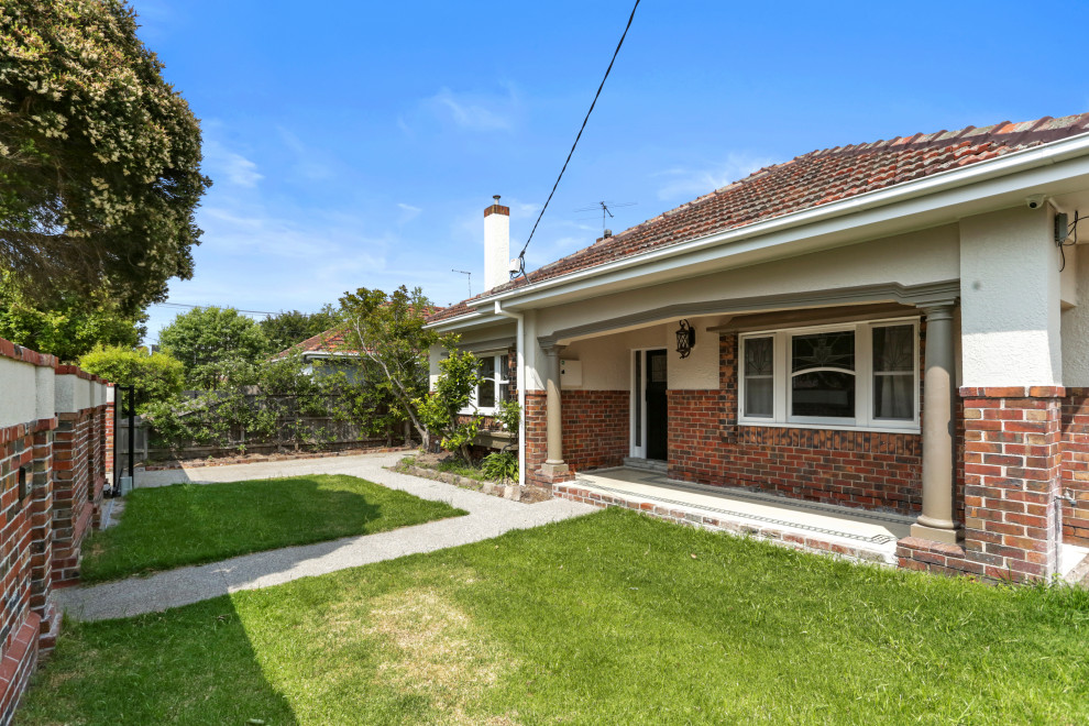 Photo of a medium sized and multi-coloured mediterranean bungalow brick detached house in Melbourne with a hip roof and a tiled roof.