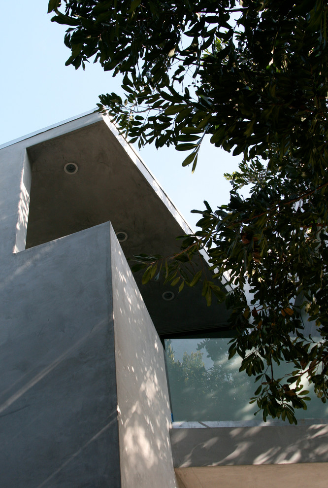 На фото: двухэтажный, серый дом среднего размера в современном стиле с облицовкой из цементной штукатурки и плоской крышей с
