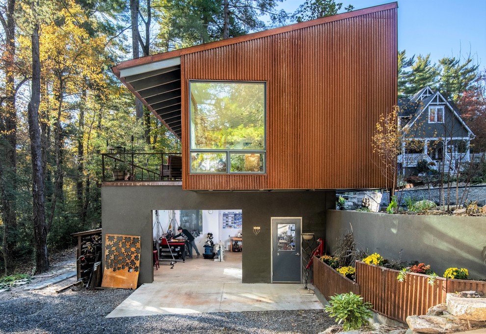 На фото: двухэтажный, коричневый частный загородный дом в стиле лофт с комбинированной облицовкой и односкатной крышей с