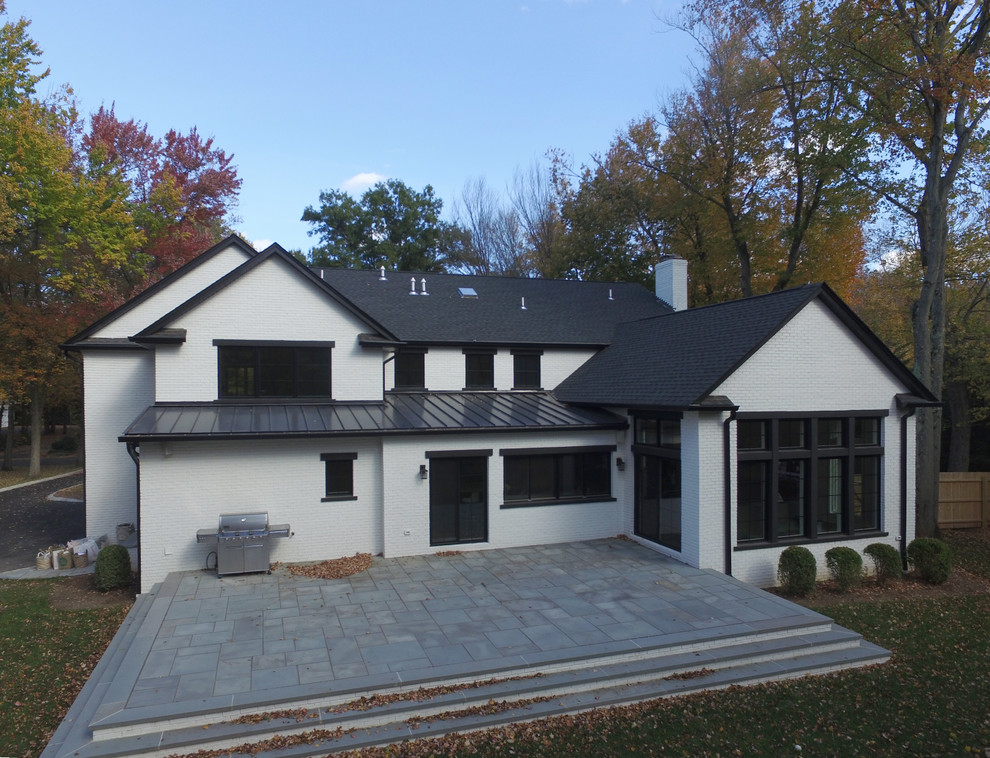Large transitional white two-story brick exterior home photo in New York with a shingle roof