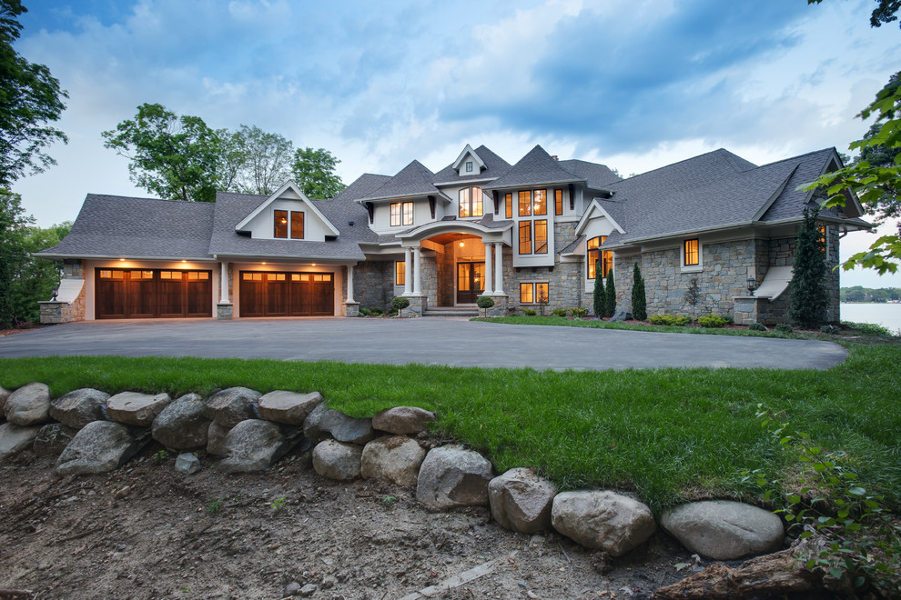 Design ideas for a large and gey traditional house exterior in Minneapolis with three floors, stone cladding and a pitched roof.