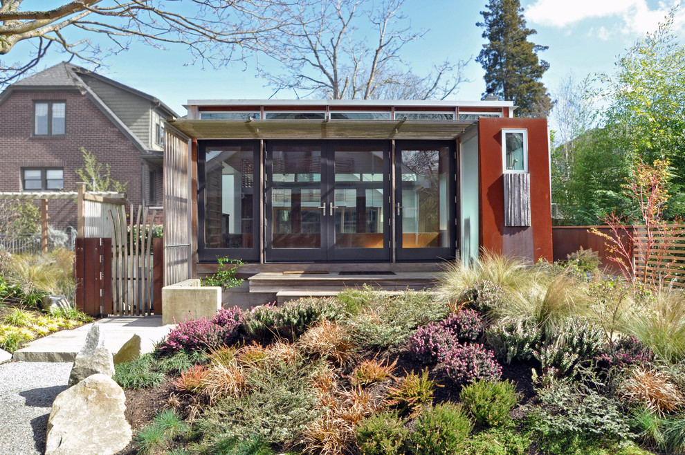 Imagen de fachada marrón minimalista de tamaño medio de dos plantas con revestimiento de metal