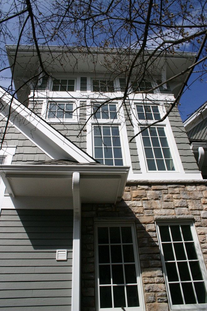 Immagine della facciata di una casa grande grigia classica a due piani con rivestimento in legno e tetto a capanna