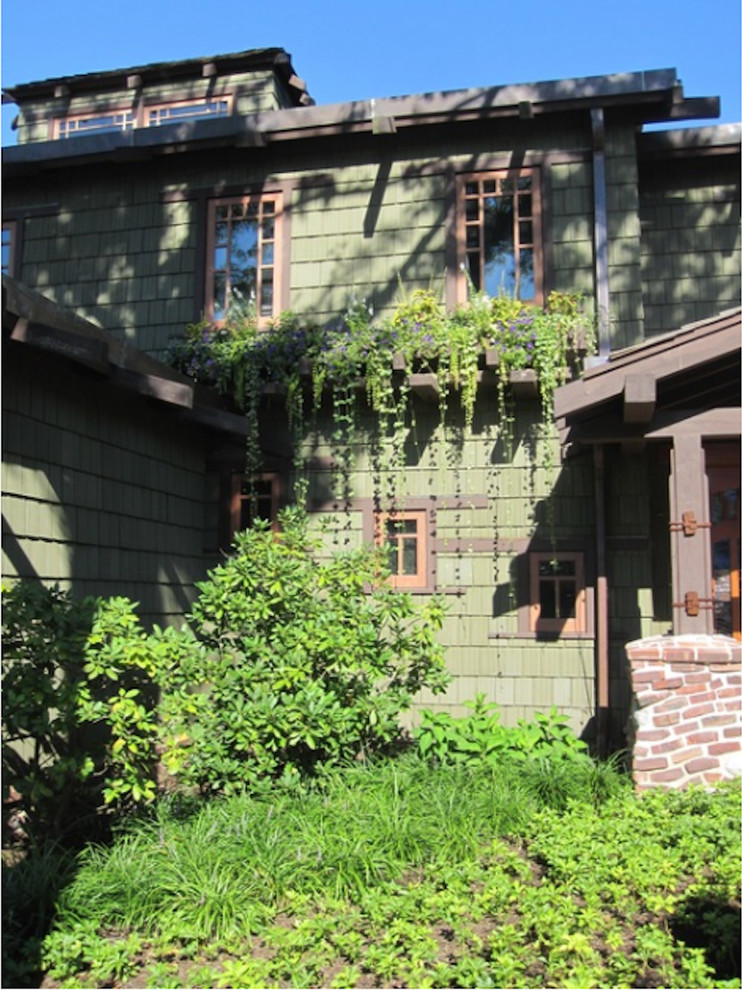 Idées déco pour une façade de maison verte montagne en bois de taille moyenne et à un étage avec un toit à deux pans et un toit en shingle.