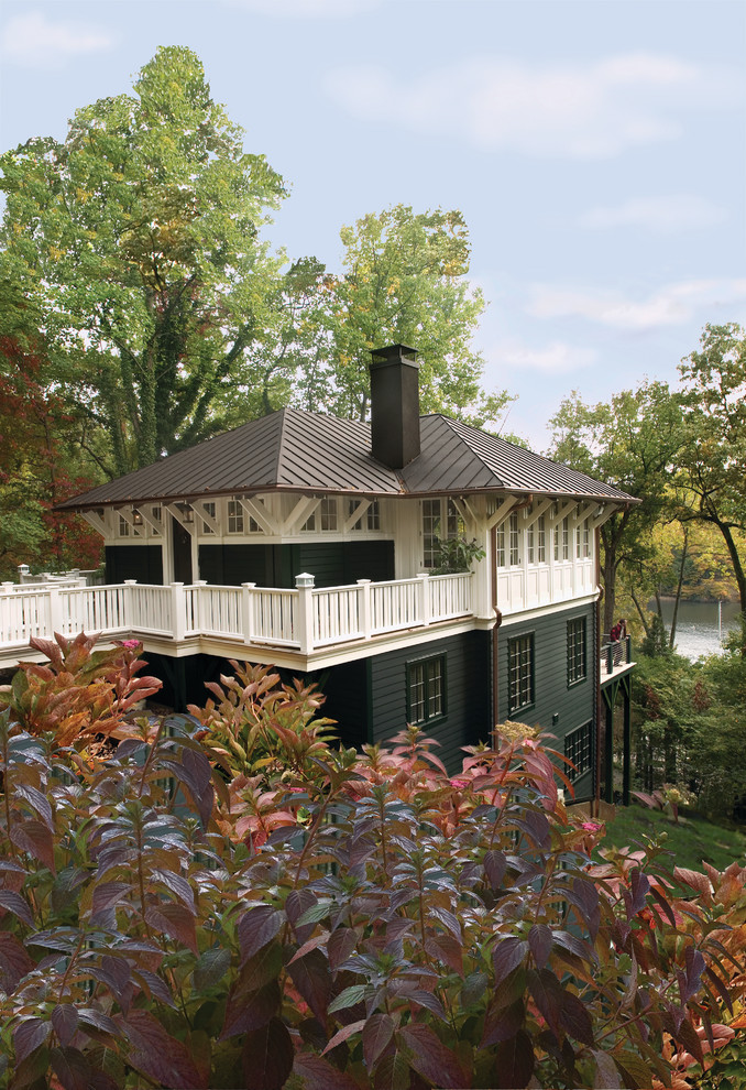 Foto på ett amerikanskt grönt hus, med tre eller fler plan, valmat tak och tak i metall