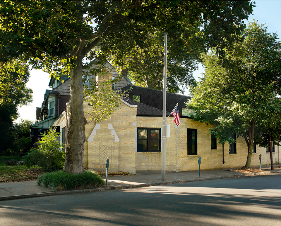 Immagine della facciata di una casa beige classica con rivestimento in mattoni e tetto a capanna