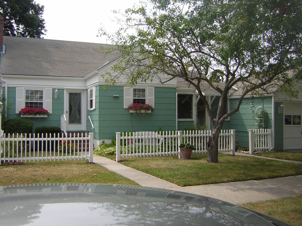 Medium sized and green traditional bungalow house exterior in Philadelphia with concrete fibreboard cladding and a pitched roof.