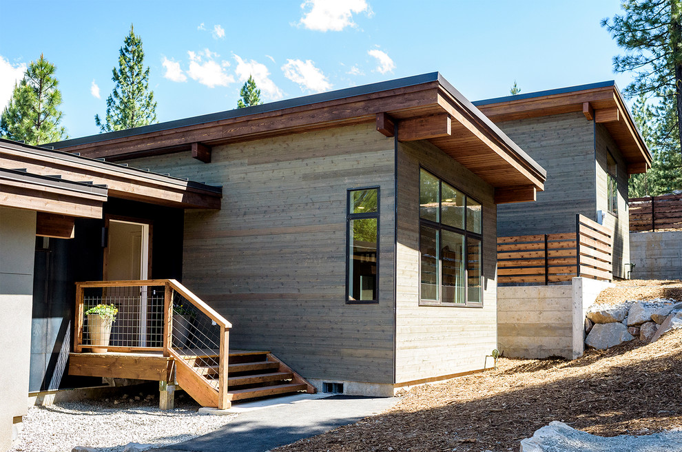 Inspiration pour une façade de maison marron minimaliste en bois de taille moyenne et de plain-pied avec un toit en appentis et un toit en métal.
