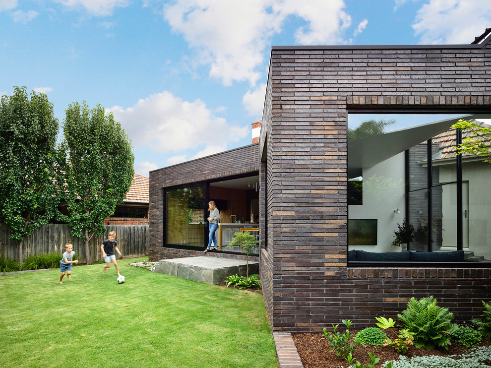 Diseño de fachada de casa marrón contemporánea de tamaño medio de dos plantas con revestimiento de ladrillo, tejado plano y tejado de metal