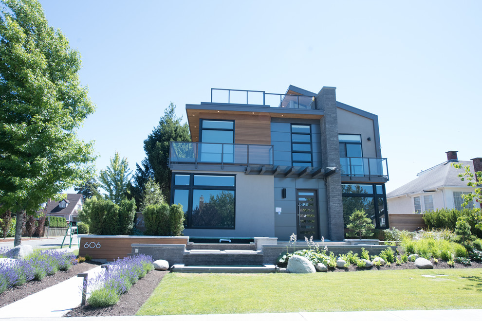 Стильный дизайн: большой, двухэтажный, серый дом в стиле модернизм с комбинированной облицовкой и плоской крышей - последний тренд