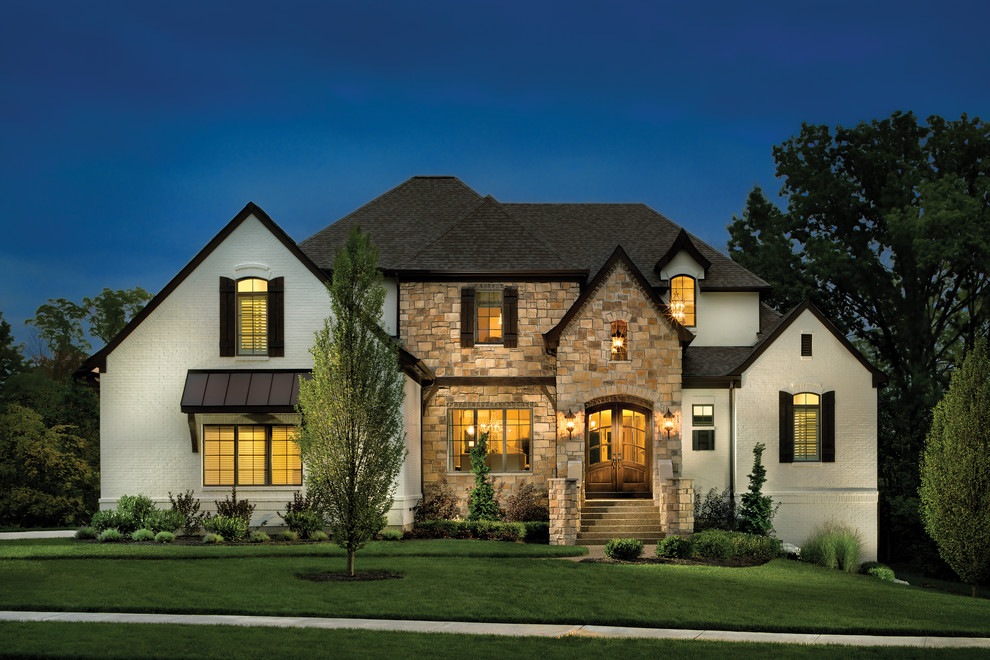 Cette image montre une grande façade de maison blanche traditionnelle à un étage avec un revêtement mixte et un toit à quatre pans.