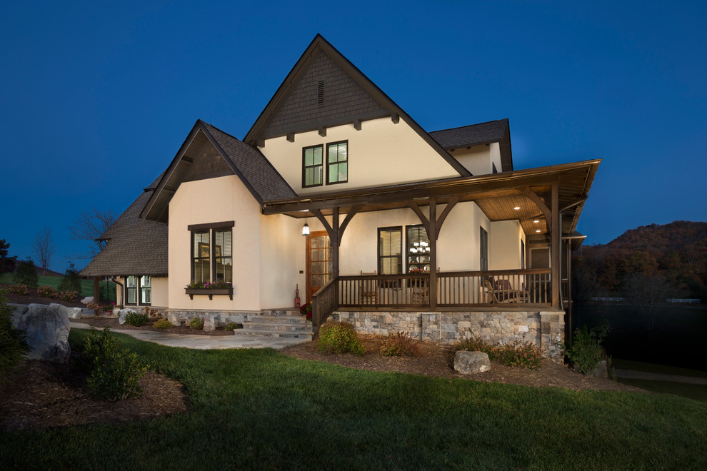 Example of a mid-sized mountain style beige two-story stucco exterior home design in Other