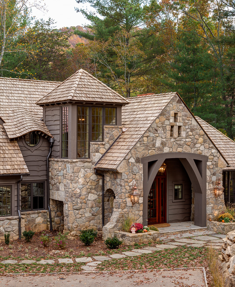 Inspiration pour une façade de maison marron chalet en pierre à un étage.