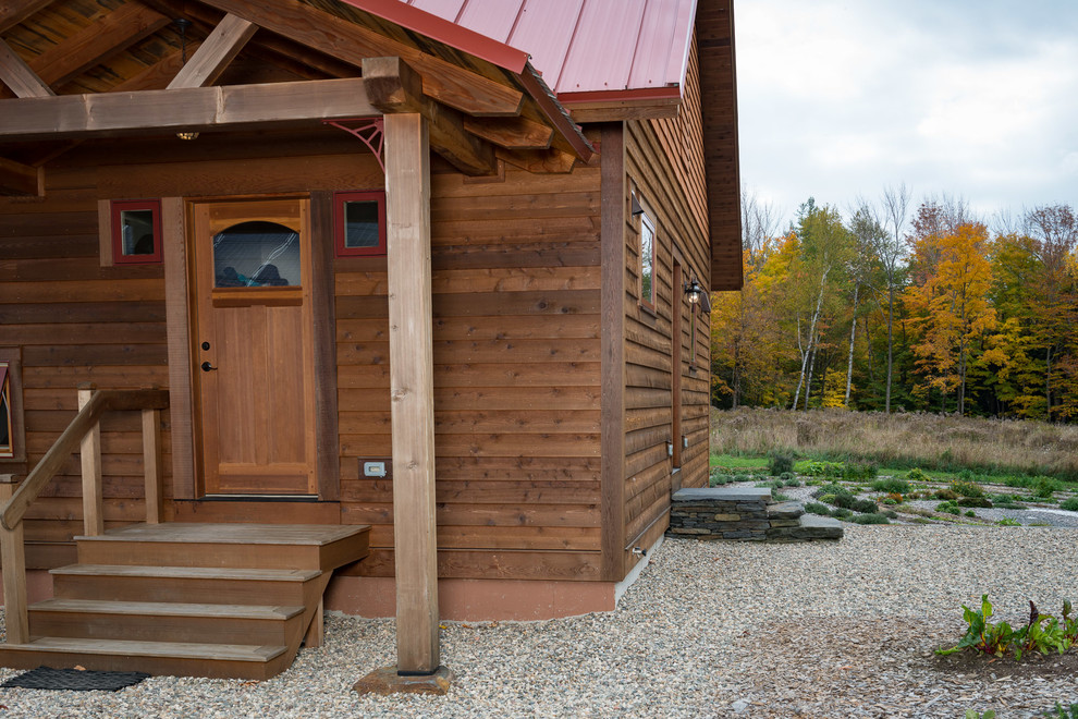 Cette image montre une façade de maison rustique en bois de taille moyenne et de plain-pied avec un toit à deux pans.