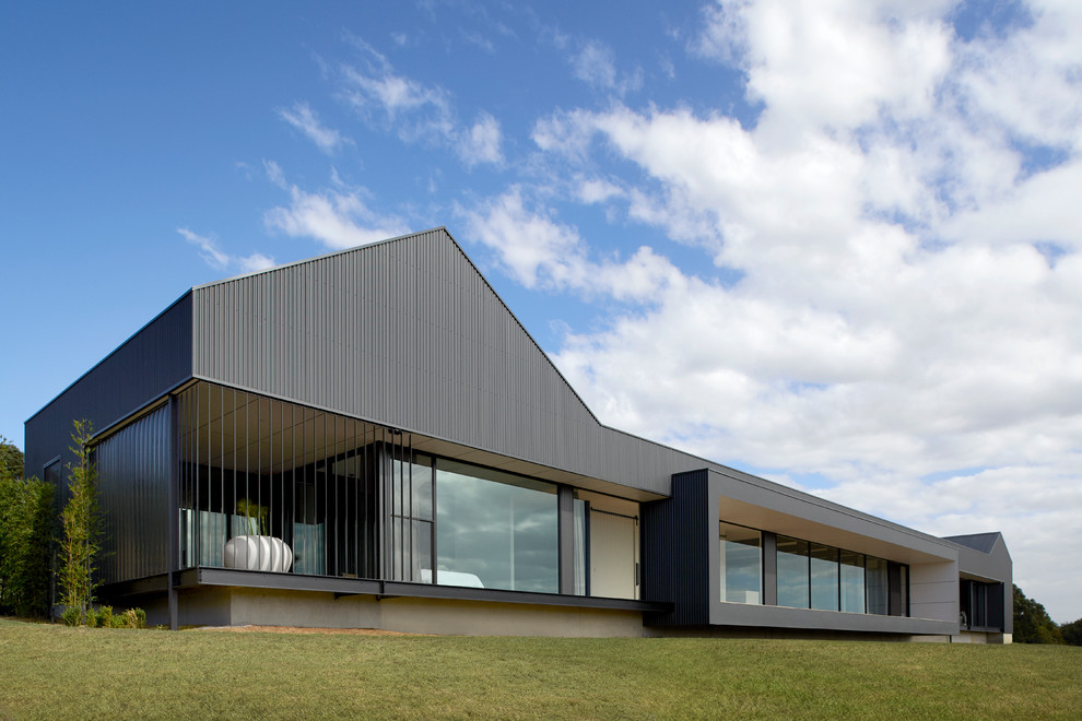 Modelo de fachada de casa negra contemporánea de una planta con tejado plano
