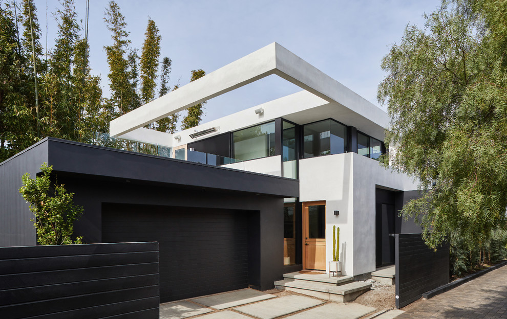 Mittelgroßes, Zweistöckiges Modernes Einfamilienhaus mit Putzfassade, weißer Fassadenfarbe, Flachdach und Schindeldach in Los Angeles