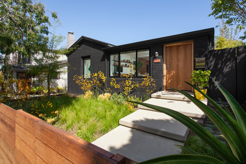 Photo of a medium sized and black traditional two floor brick detached house in Los Angeles with a pitched roof and a shingle roof.