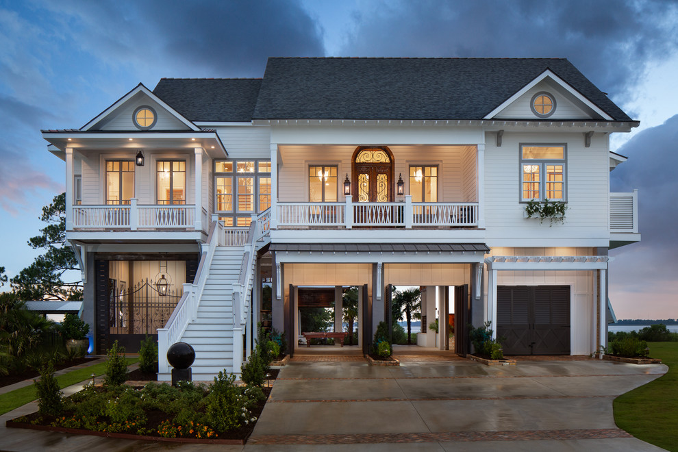 Zweistöckiges Maritimes Einfamilienhaus mit weißer Fassadenfarbe, Satteldach, Schindeldach und Dachgaube in New Orleans