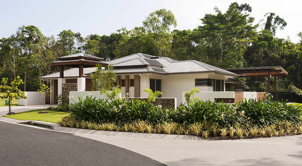 На фото: белый частный загородный дом в восточном стиле с вальмовой крышей и металлической крышей с