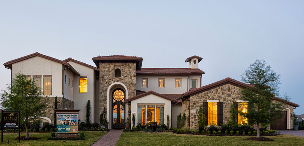 Example of a huge classic beige two-story stone exterior home design in Houston with a hip roof