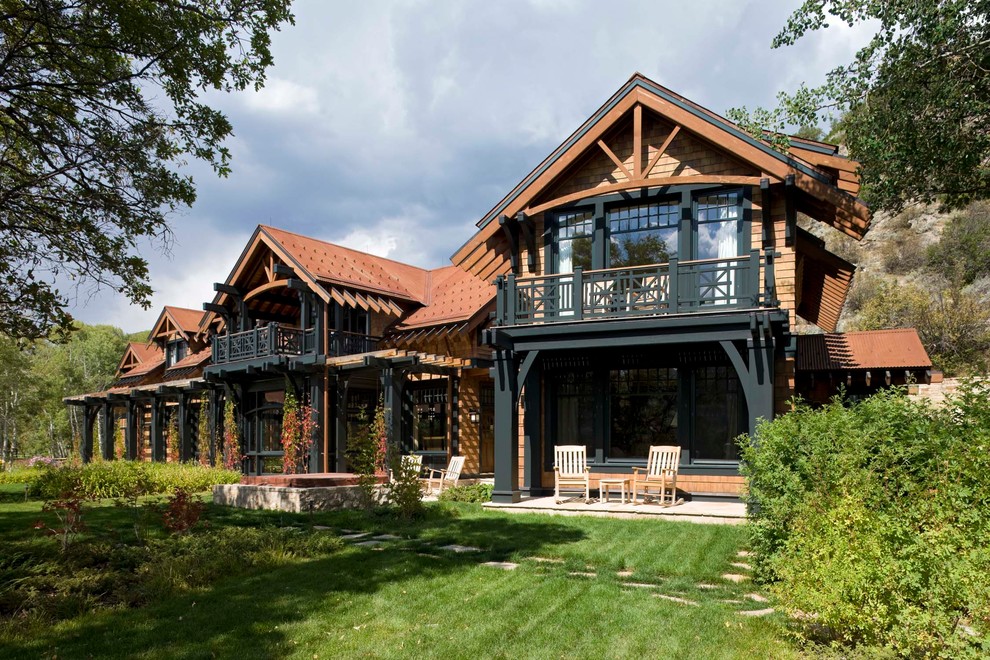 Large and beige rustic two floor house exterior in Denver with wood cladding and a pitched roof.
