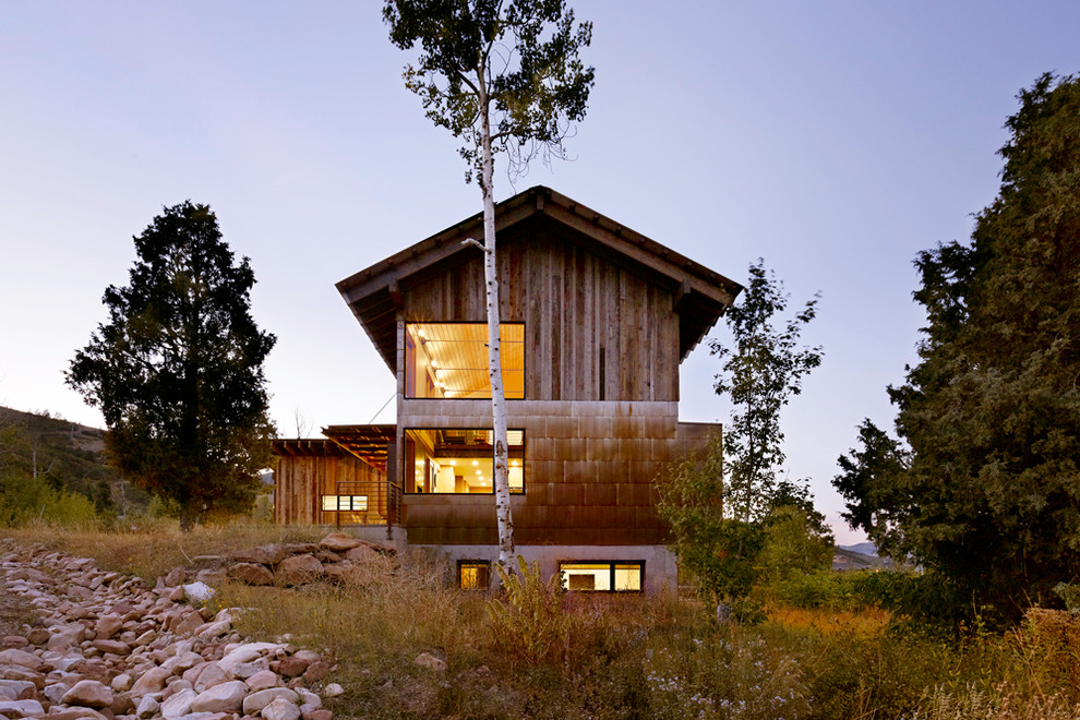 Diseño de fachada rural de tamaño medio de dos plantas con revestimiento de madera y tejado a dos aguas