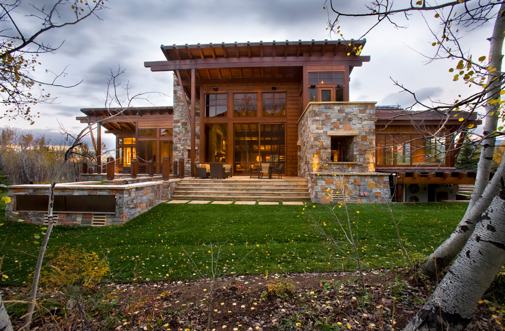 Large mountain style beige two-story stone house exterior photo in Denver