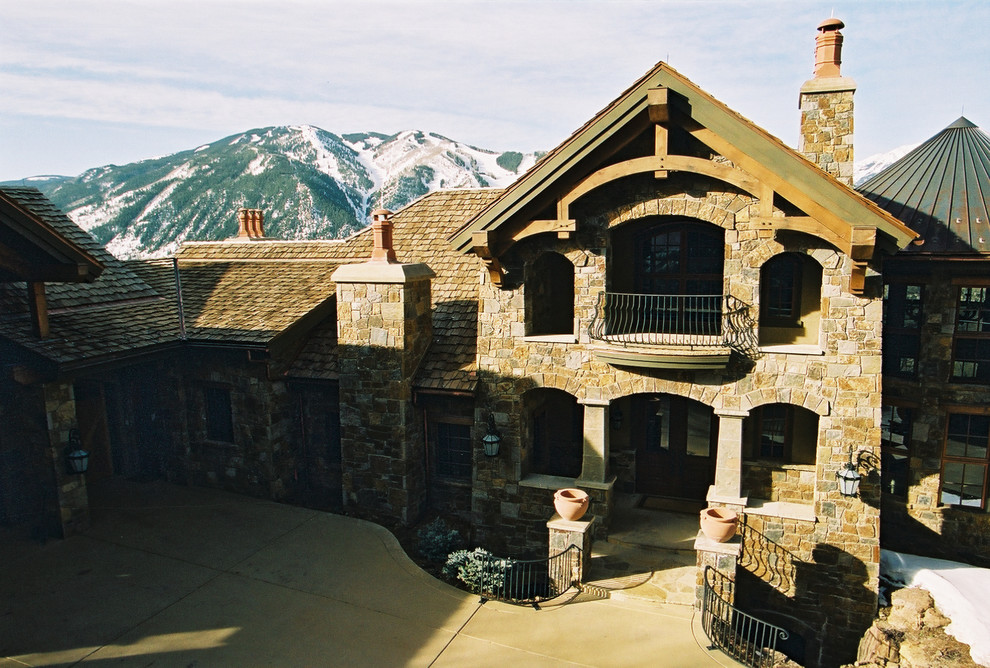 Foto della facciata di una casa ampia marrone rustica a due piani con tetto a capanna e rivestimenti misti