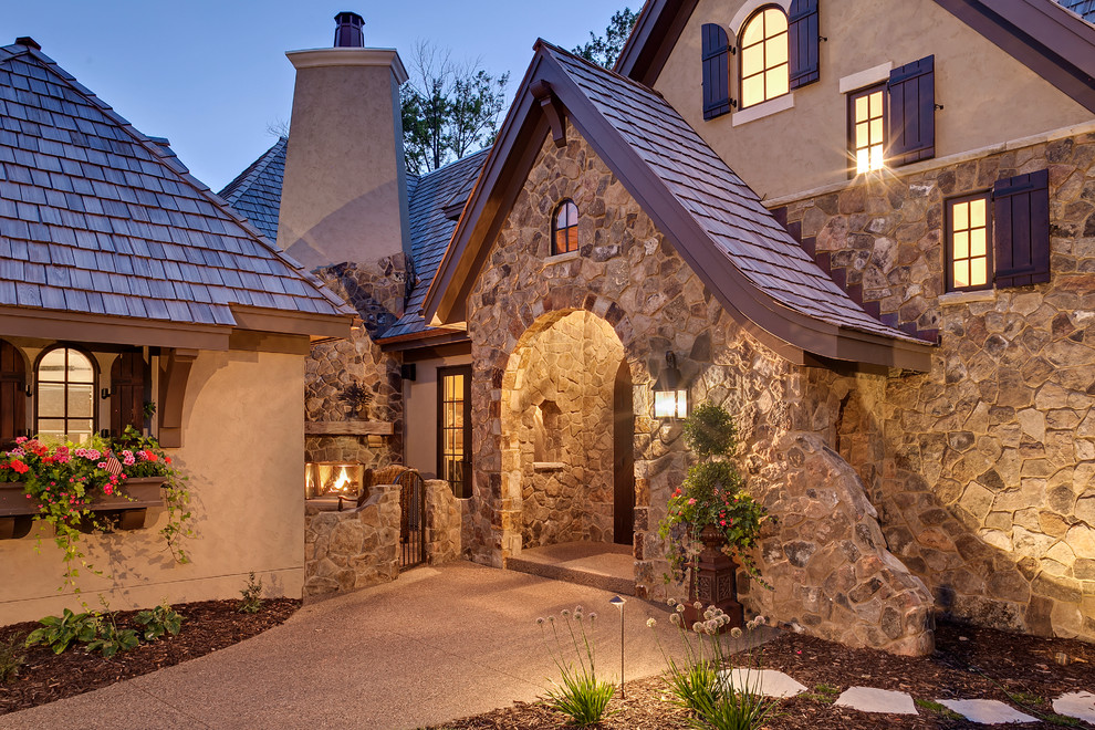 Inspiration pour une façade de maison beige traditionnelle en pierre à deux étages et plus.