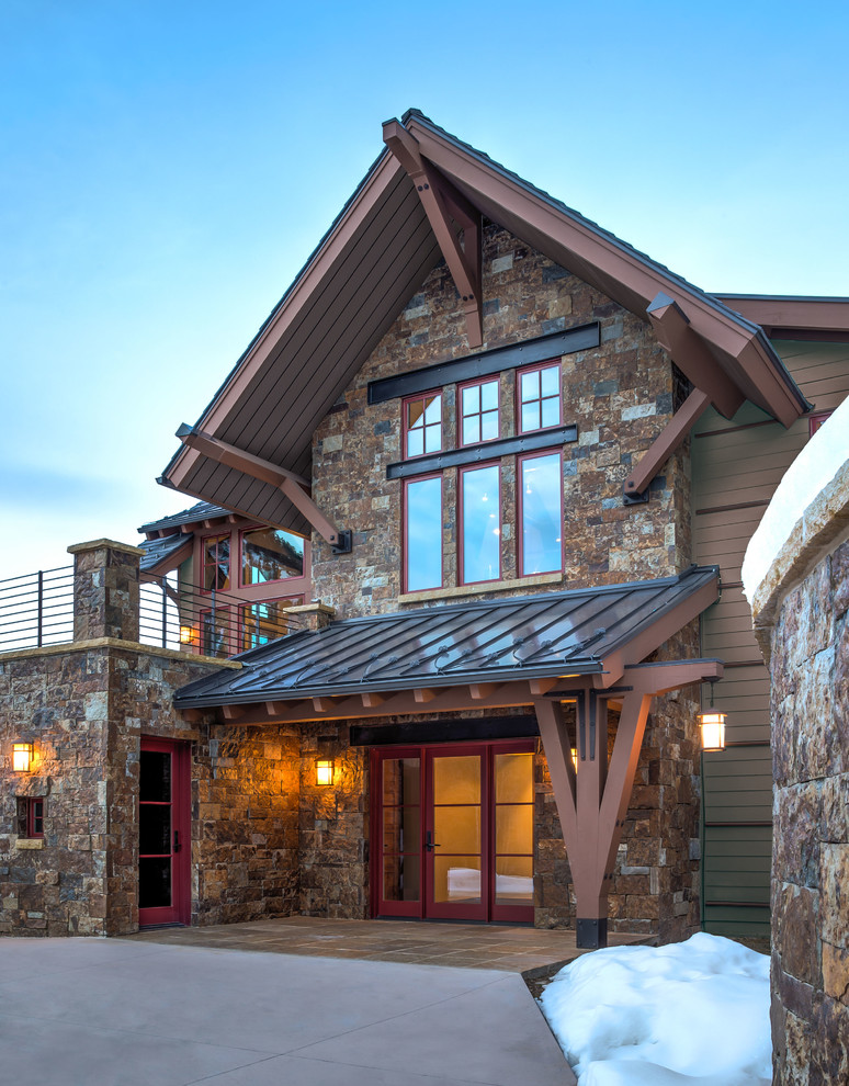 Inspiration for a rustic two floor house exterior in Denver with stone cladding and a pitched roof.