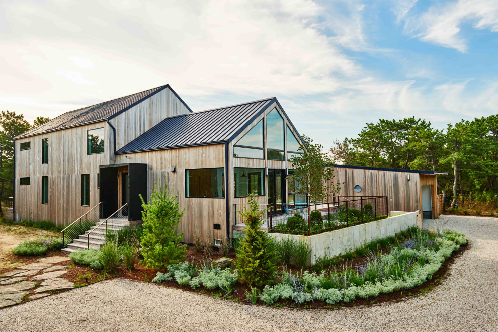 Contemporary two-story wood exterior home idea in New York with a metal roof