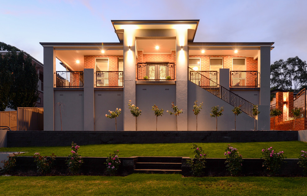 Réalisation d'une façade de maison multicolore design à un étage avec un revêtement mixte et un toit plat.