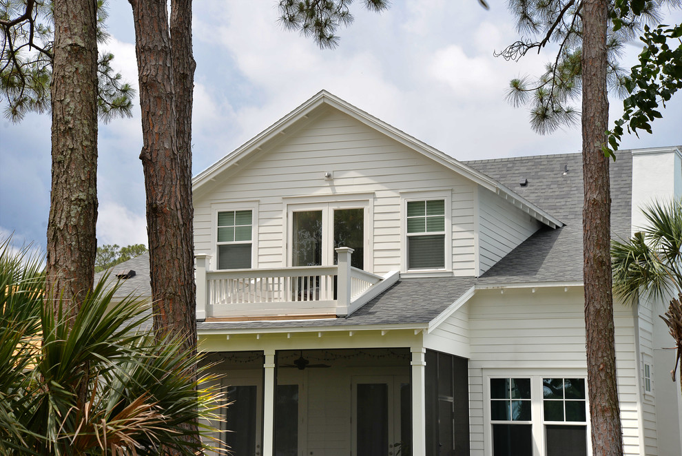 Esempio della facciata di una casa bianca stile marinaro a due piani di medie dimensioni con rivestimento con lastre in cemento e tetto a capanna