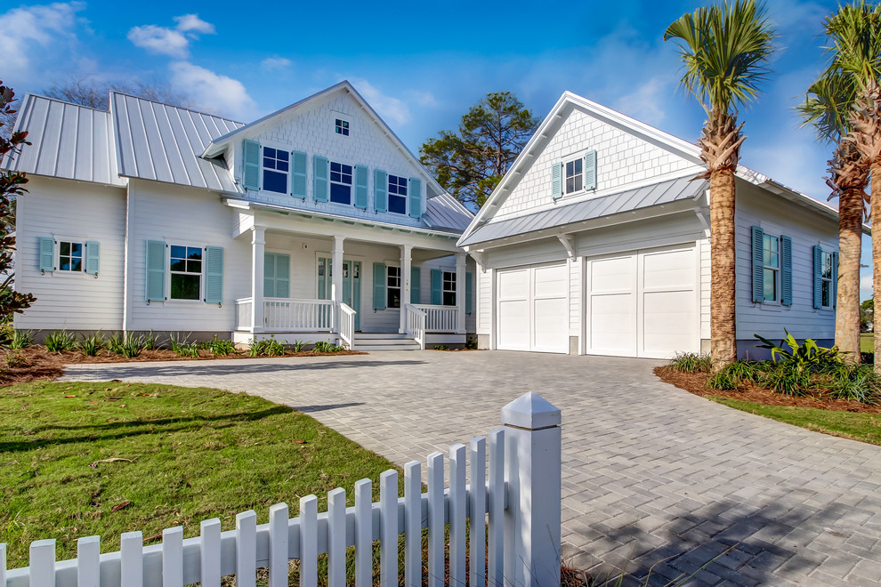 This is an example of a medium sized and white coastal two floor detached house in Jacksonville with wood cladding, a hip roof and a shingle roof.