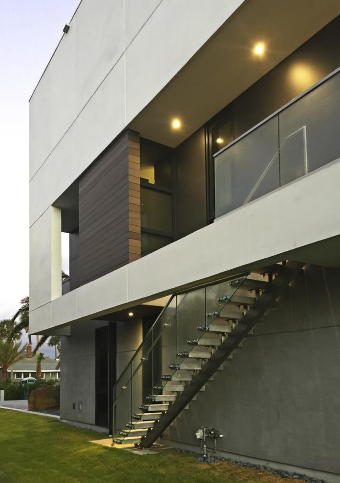 Aménagement d'une grande façade de maison grise moderne en béton à deux étages et plus avec un toit plat.