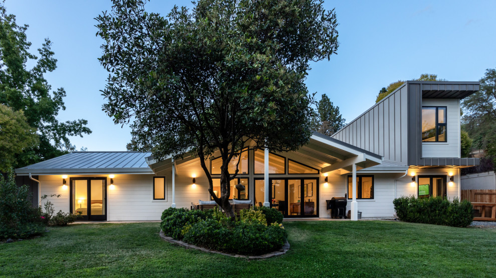 Zweistöckiges Mid-Century Einfamilienhaus mit weißer Fassadenfarbe, Satteldach und Blechdach in Sacramento