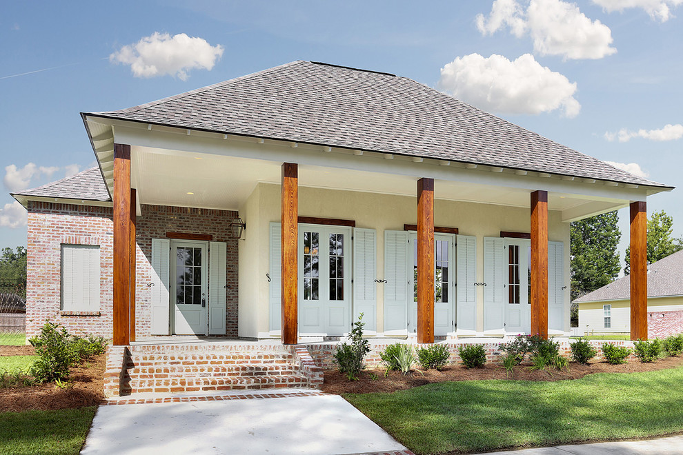Mittelgroßes, Einstöckiges Landhausstil Haus mit Mix-Fassade und gelber Fassadenfarbe in New Orleans