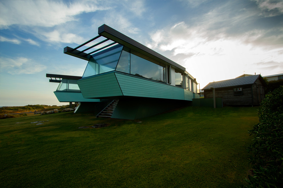 Réalisation d'une façade de maison verte design de taille moyenne et de plain-pied avec un revêtement mixte.